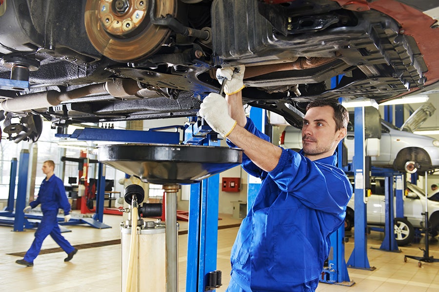Technician performing work underneath a vehicle